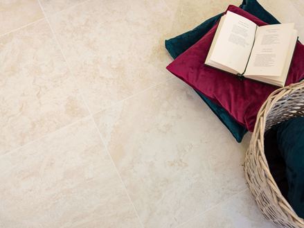 Fliser i travertin-look med puder og en åben bog