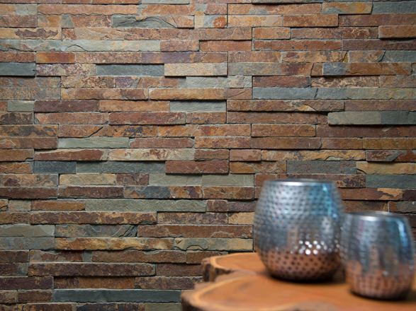 To vaser på et træbord foran en vægbeklædning af naturskifer i lyse nuancer