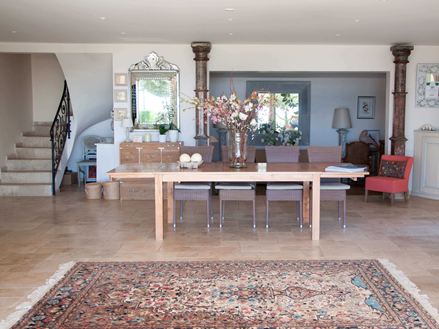 Indgangsparti på et hotel med persisk tæppe og træbord på travertinfliser