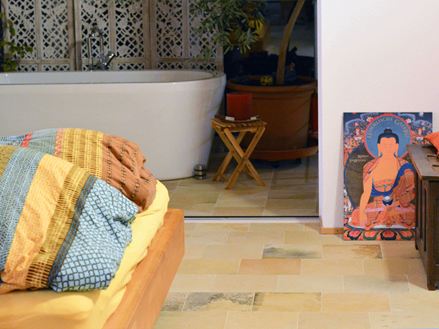 Soveværelse med farverige puder og Solnhofen-kalkstensgulv