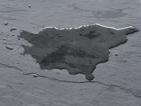 Mørk skiferflise med vandpyt