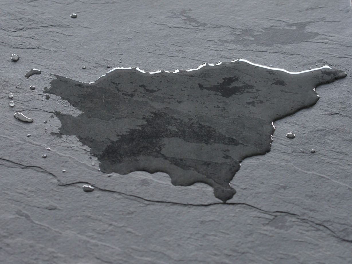 Mørk skiferflise med vandpyt