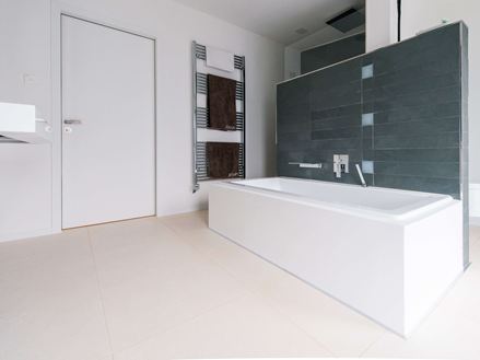 Badeværelse med badekar og fliser af Miros-kalksten, børstet