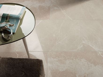 Rundt bord med bog og ur på Burdur Cream-marmorflise