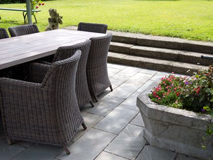 Rattanmøbler på grå sandstensplader