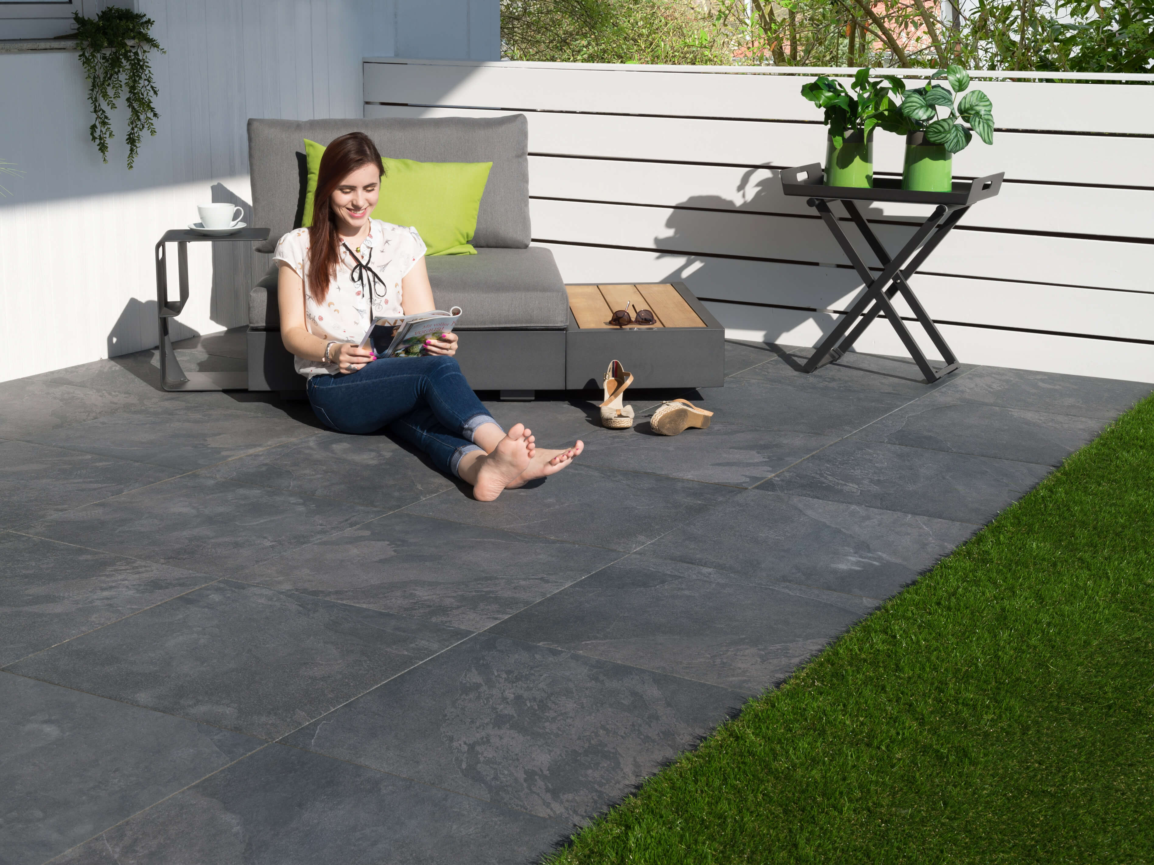 Kvinde sidder på terrasseplader Alpine Black