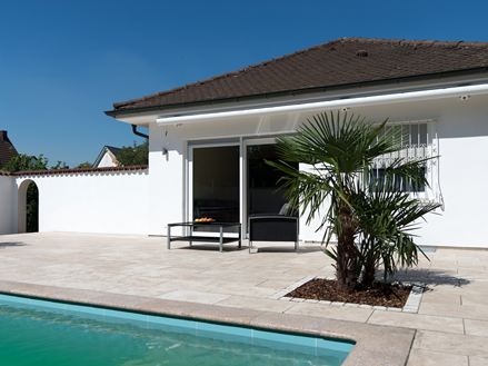 Middelhavsterrasse i travertin med tjørn og palme