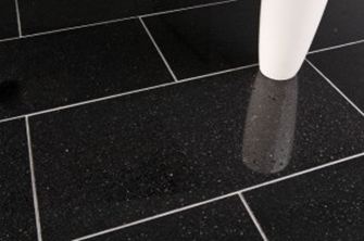 En hvid vase på sorte granitfliser med lyse fuger