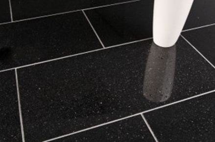 En hvid vase på sorte granitfliser med lyse fuger