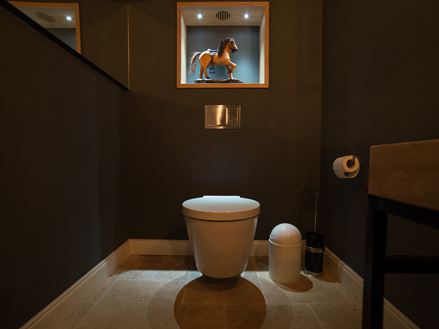 Sort badeværelse med travertinfliser