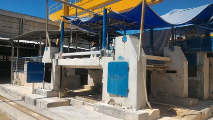 En båndsav skærer en rå stenblok i såkaldte "skiver"