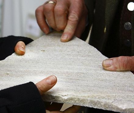 To hænder holder et stykke natursten fra Taunus-kvartsit