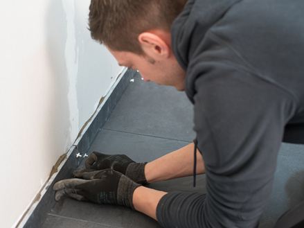 Flisemurer installerer fodpaneler