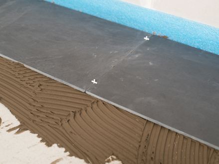 Fugekryds som afstandsstykke mellem to skiferfliser