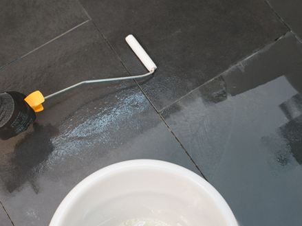 Imprægneringsmiddel påføres den udlagte sten med en rulle