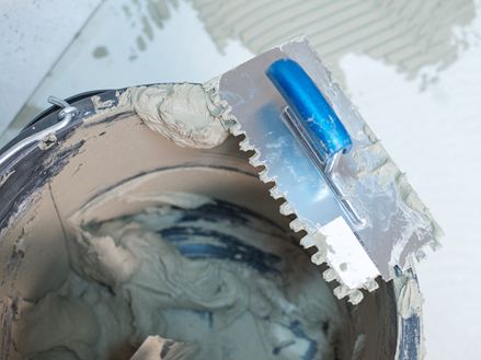 En spand naturstensklæber og en tandspartel