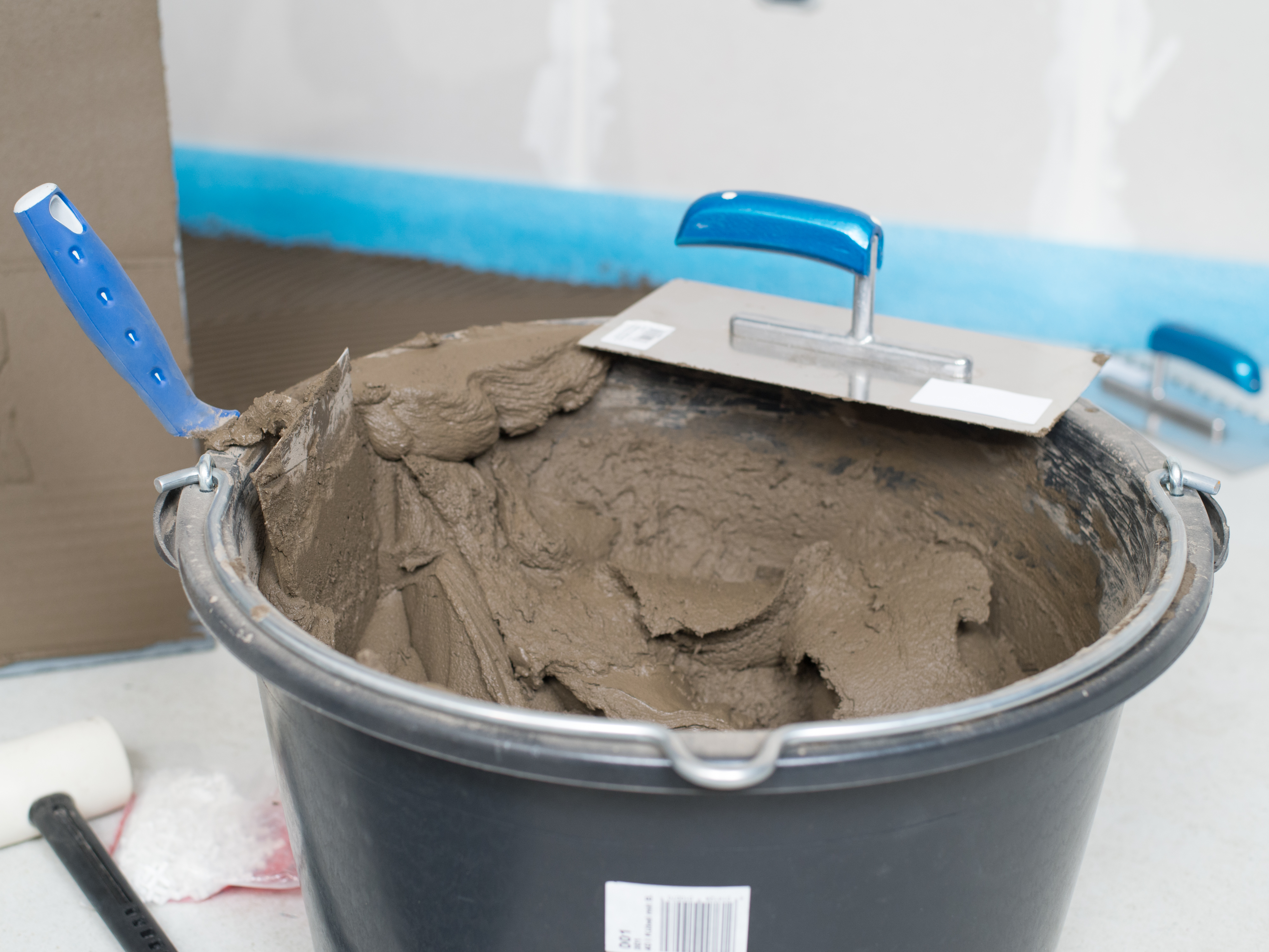 En spand naturstensklæber og en tandspartel