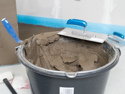 En spand naturstensklæber og en tandspartel