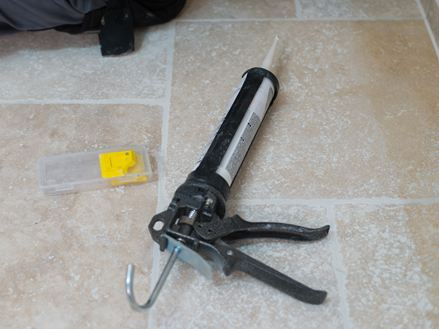 Silikonepatron og spartel på et travertingulv