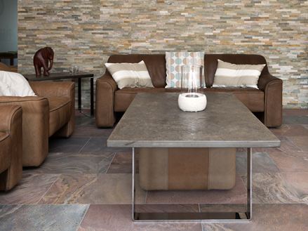 Stue med brune sofamøbler, rødlige kvartsitfliser på gulvet og naturstenspaneler på væggen