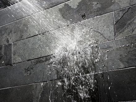 Vand på en mørk stenvæg i badeværelset