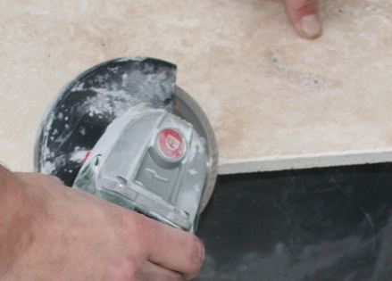 En stenplade saves til med en vinkelskærer